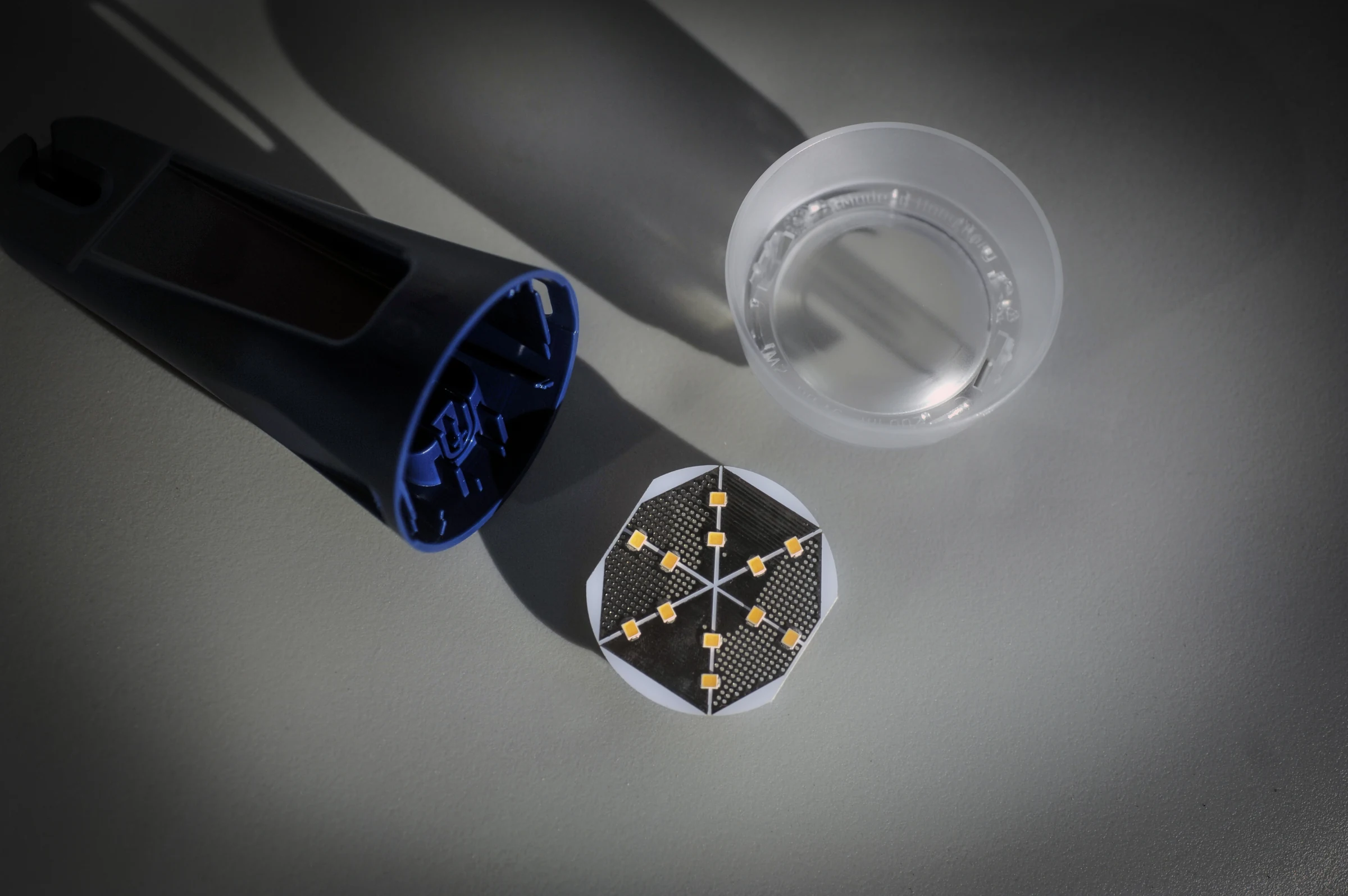 Architecture de Lumina ONE : un boîtier bleu moulé, une seule carte LED circulaire et un diffuseur translucide