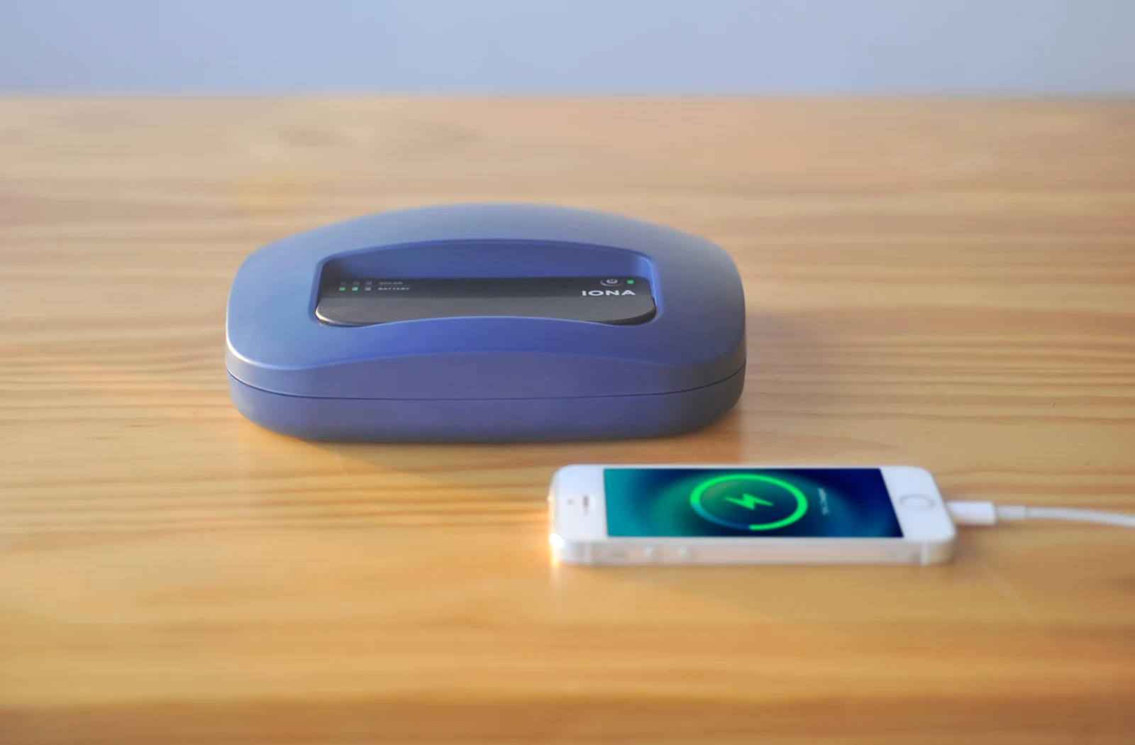 IONA HOME MAX solar home system charging a smartphone through its USB port