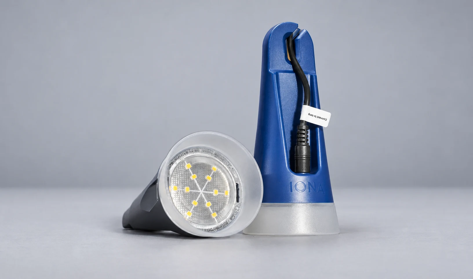 Two blue IONA Lumina ONE pendant lights showing the circular LED diffuser and integrated cable clamp