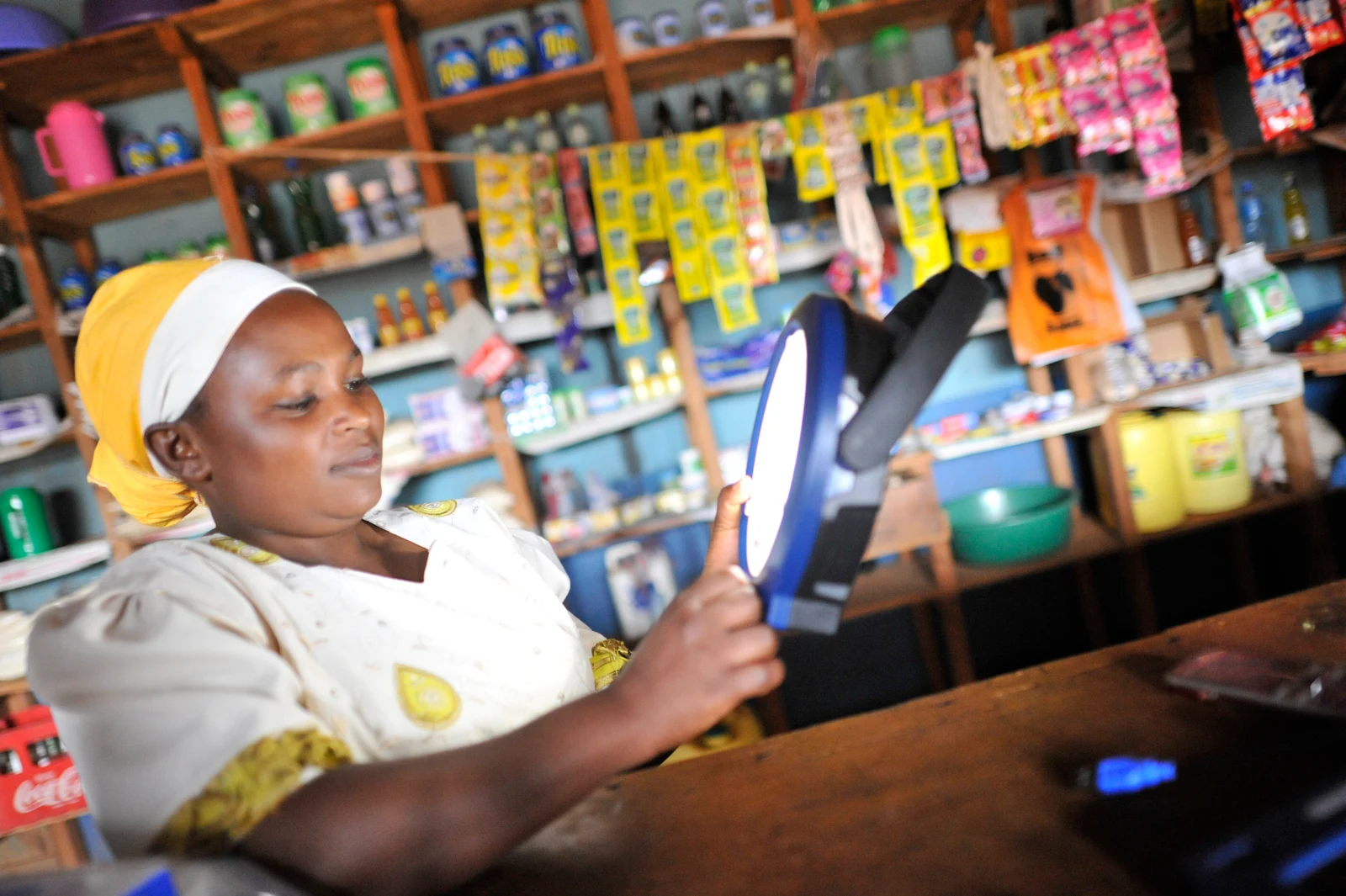 A customer holding a NIWA MULTI solar lantern in a shop in Kenya