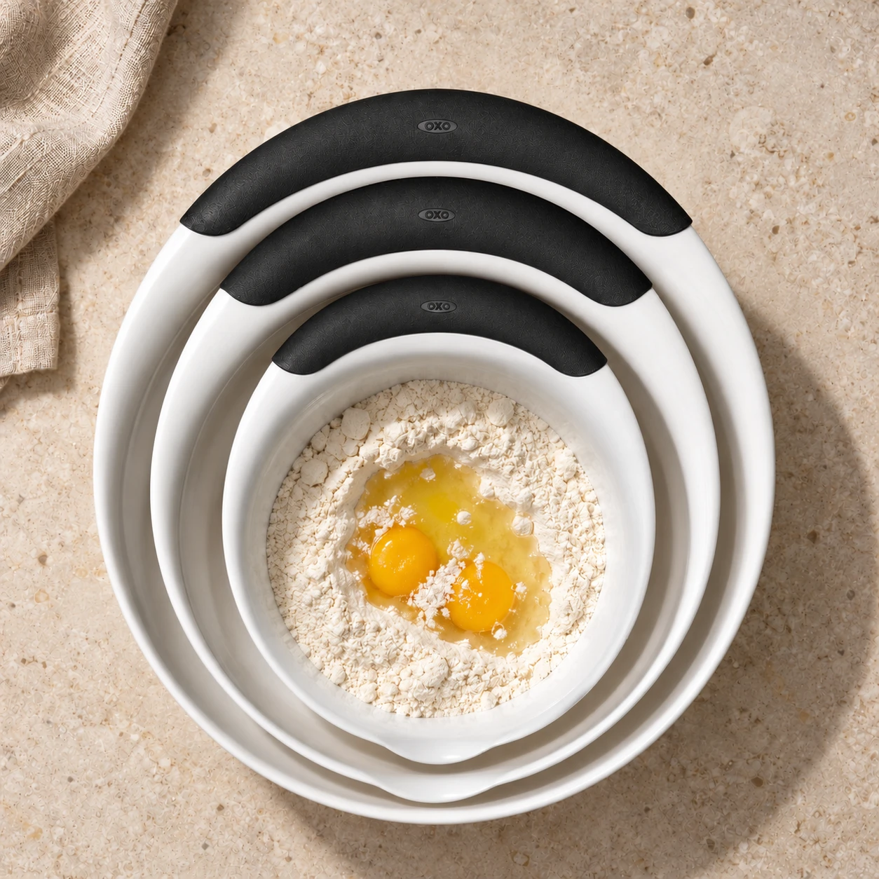 OXO Good Grips mixing-bowl product design: nested bowls with flour and eggs in the smallest bowl